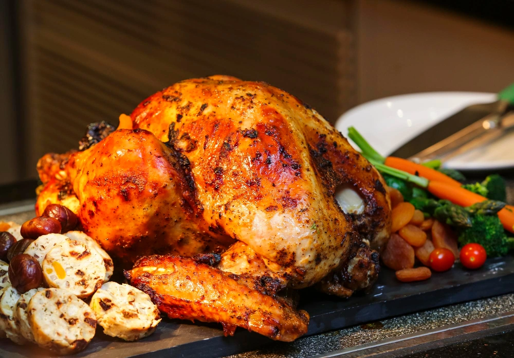 A plate of baked adobo chicken served with vegetables.