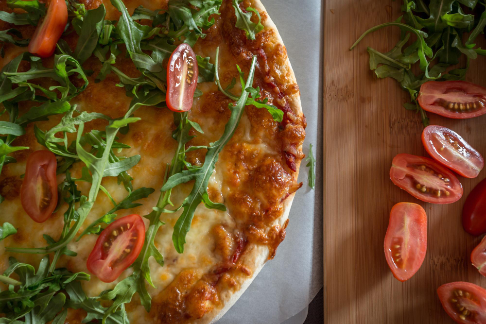 A delicious biscuit breakfast pizza topped with scrambled eggs, cheese, and colorful vegetables, served on a wooden cutting board.