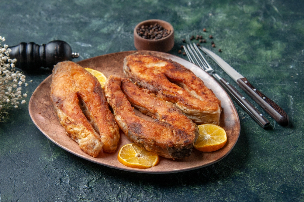 Delicious fried salmon bites served with lemon wedges.