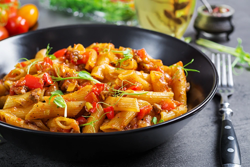 A bowl of curry pasta with chicken, featuring creamy curry sauce, tender chicken pieces, and pasta.