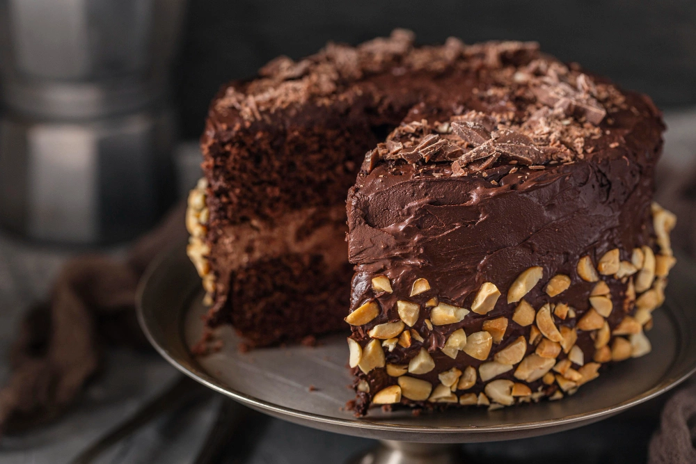 A beautifully presented German chocolate poke cake topped with a creamy chocolate, showcasing its moist layers and rich chocolate flavor.