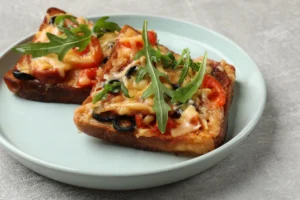 Freshly baked school breakfast pizza topped with scrambled eggs, melted cheese, and colorful vegetables.