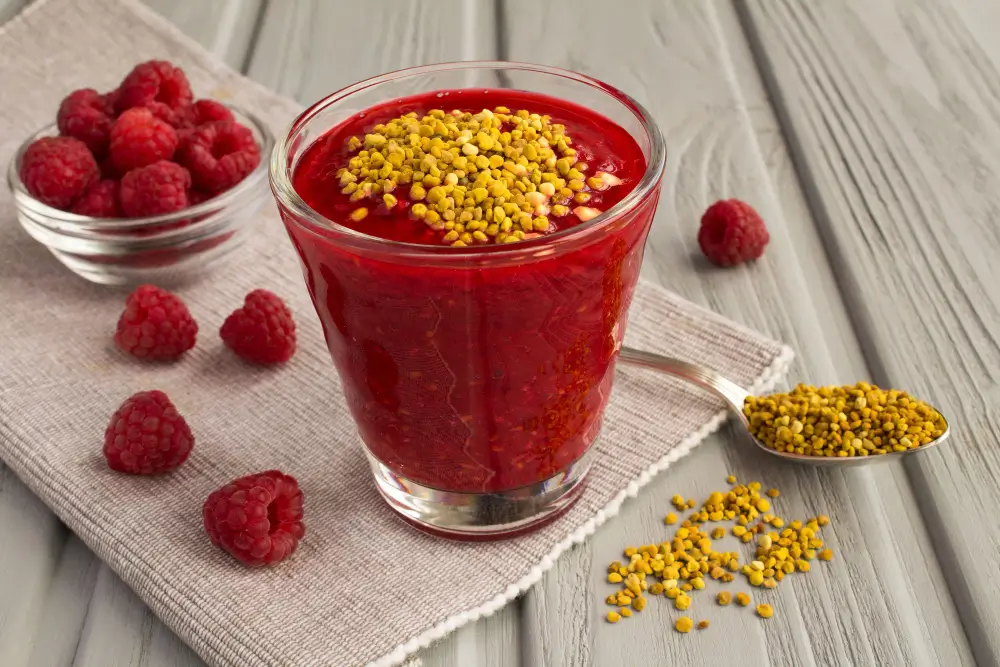 Bee Pollen Smoothie: Discover Its Health Benefits Today! 3 Smoothies with raspberries and bee pollen on the grey wooden background