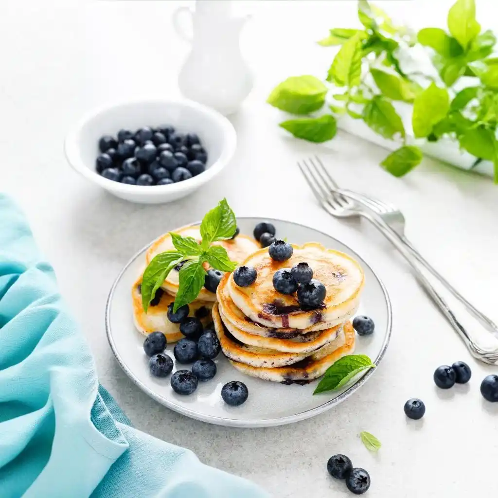 Benefits of Blueberry Pancake Mix for a Healthy Breakfast 2 Blueberry pancakes with fresh berries on breakfast table