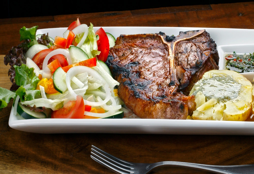 A platter of juicy sirloin steak tips served with fresh vegetables and sides