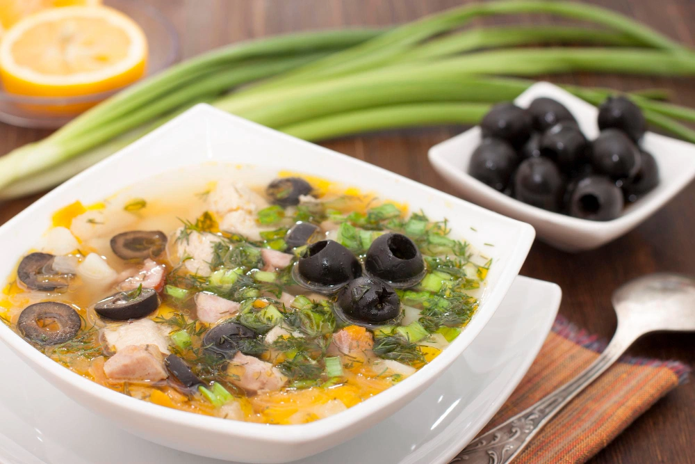 A bowl of delicious olive soup garnished with fresh herbs