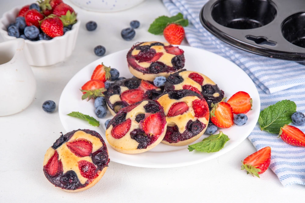 Delicious protein pancake muffins topped with fresh berries served on a plate