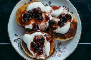 Fluffy golden biscuits made with pancake mix on a wooden plate, served with butter and jam