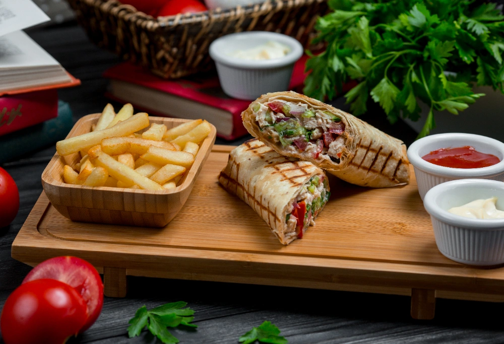 A beautifully plated Sandwiche Lahme garnished with parsley and served with side sauces.