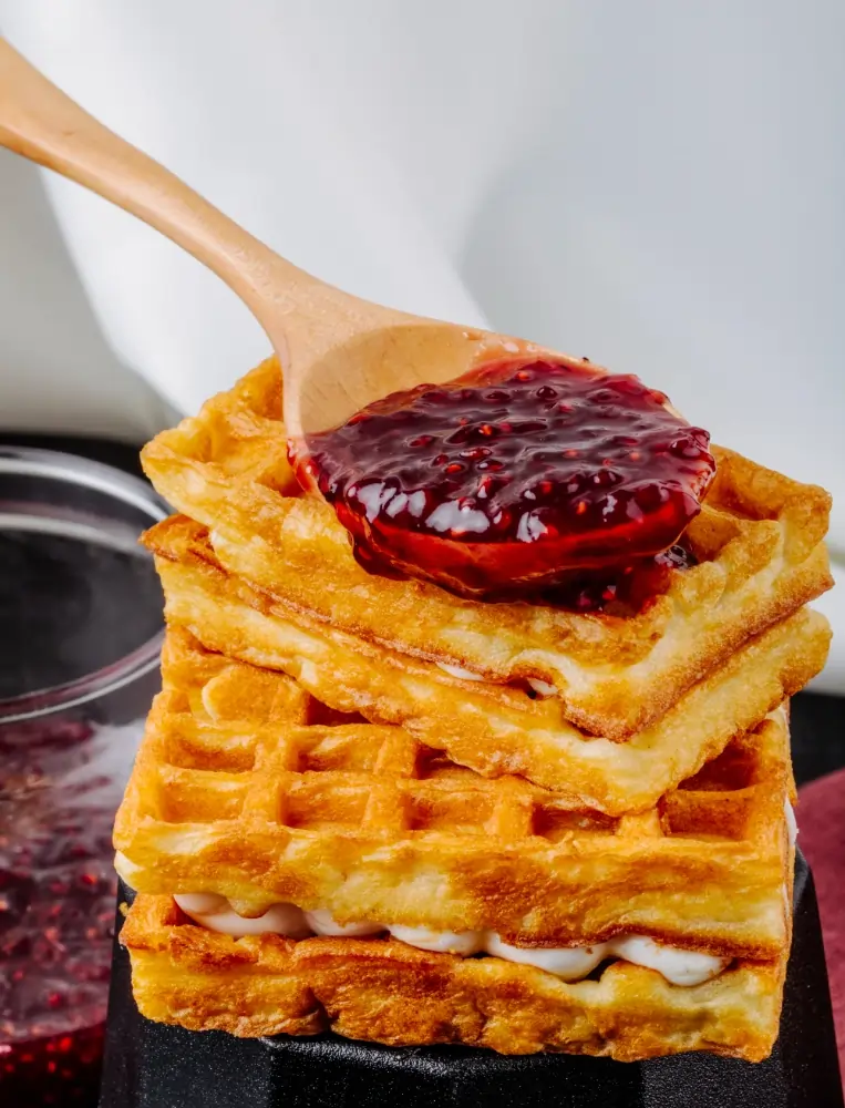 The Ultimate Guide to Vegan Protein Waffles: Healthy, Delicious, and Easy to Make 4 vegan protein waffles with vanilla cream and strawberry jam on top