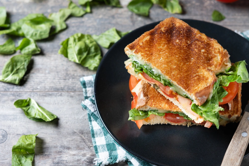 The Ultimate Guide to Chicken Caesar Salad Sandwiches 4 Close-up of a chicken caesar salad sandwich with melted cheese.
